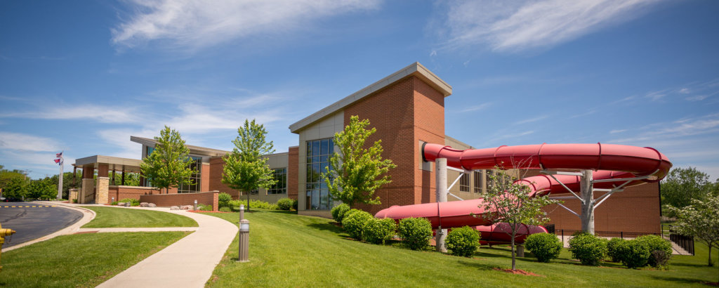 Exterior view of the Green Bay Kroc Center, featuring our big, red waterslide.