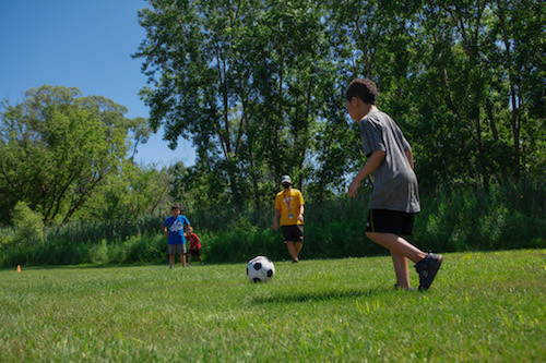Boys play soccer in the Kroc backyard.